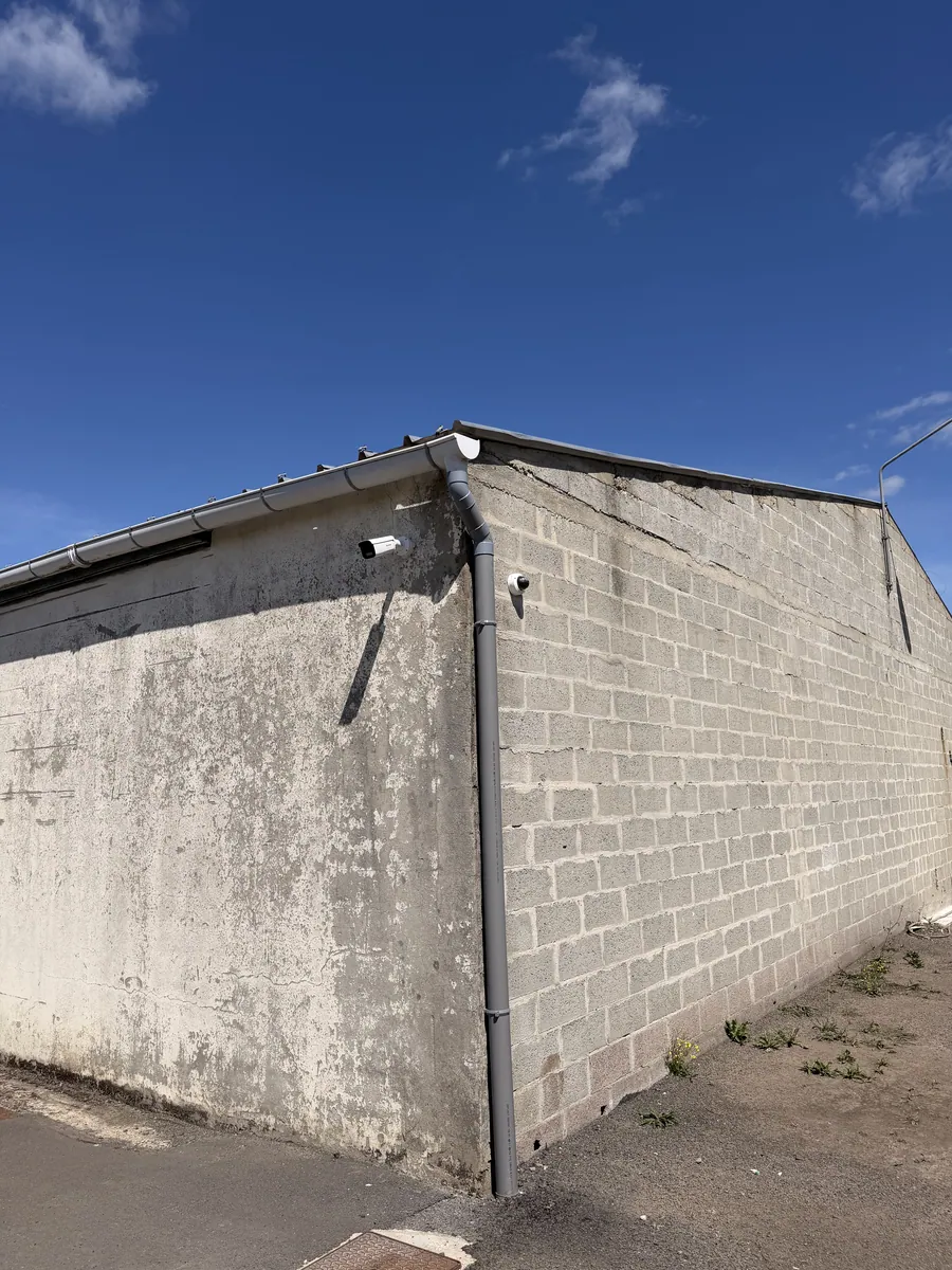 Caméra posée en angle de bâtiment pour couvrir la cour et les allées